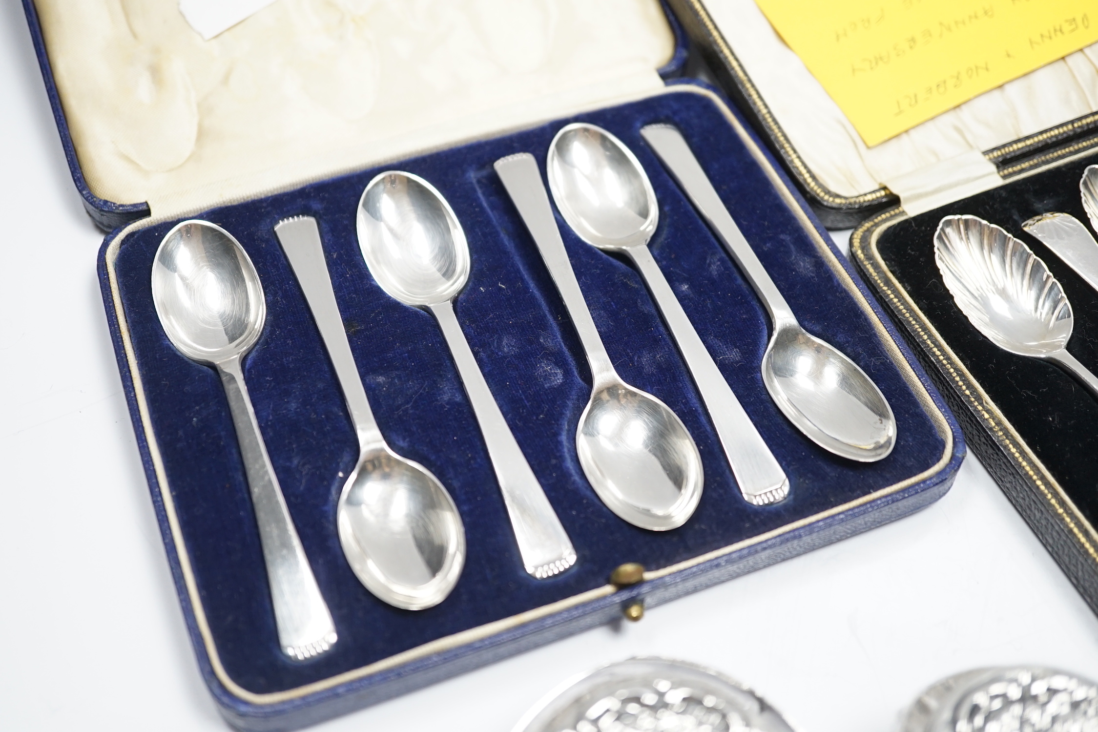 Two cased sets of six silver teaspoons, including Old English shell pattern by James Dixon & Sons, Sheffield, 1893 and Robert Pringle & Sons, Sheffield 1941, together with two silver mounted glass toilet jars and a sterl